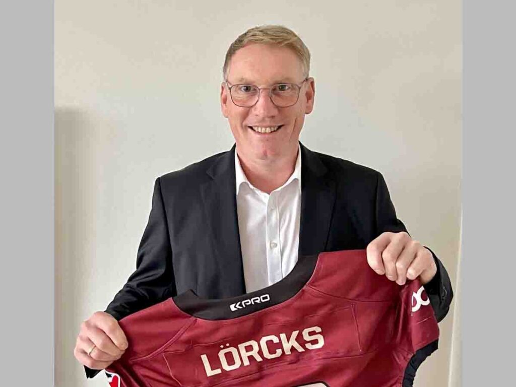 Christoph Lörcks wird neuer General Manager von Rhein Fire Person mit RhineFire-Trikot in den Händen