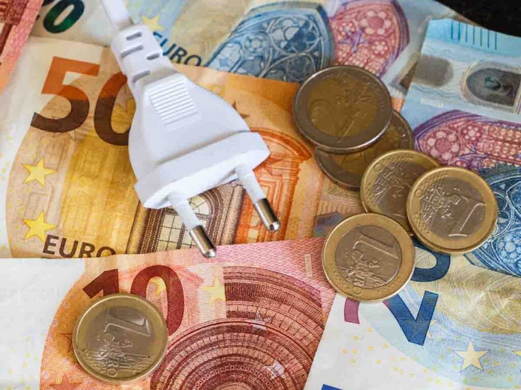 Euro coins, notes and electric plug