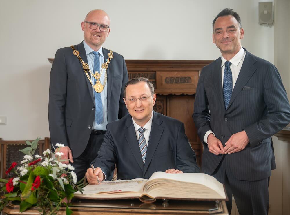 3 Personen mir Goldenem Buch der Stadt